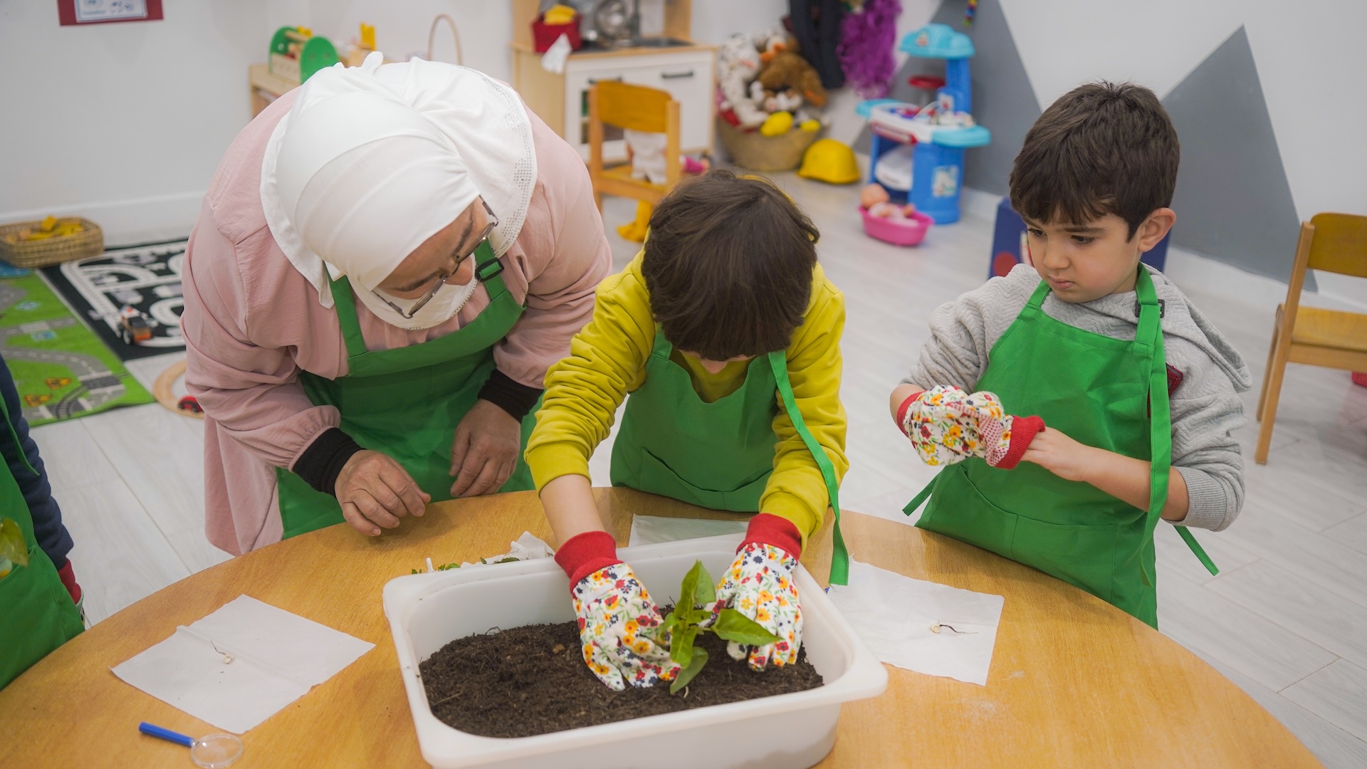 Teacher guiding a small group activity with young learners using blocks and storytelling in a play-based classroom