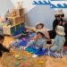 Children exploring phenomenon beach and water with the teacher