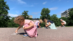 Outdoor preschool activities where a child draws numbers with chalk