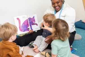 Preschool teacher supporting literacy development through curriculum-based reading