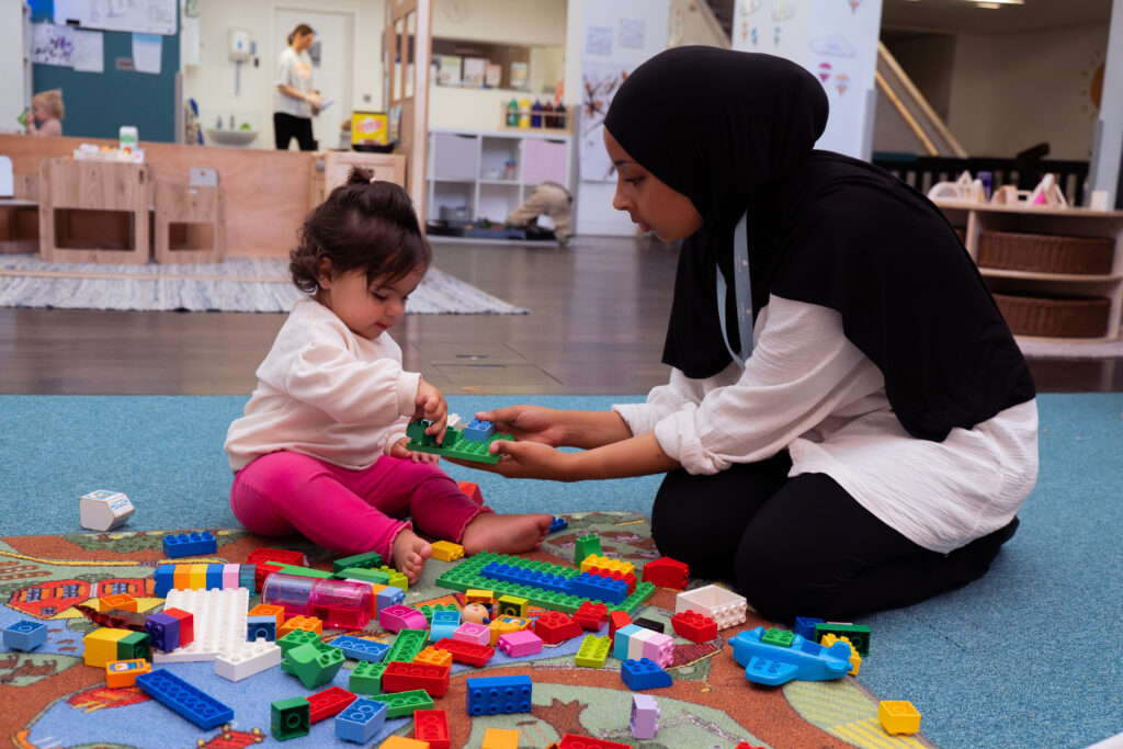 A child playing with teachers guidance in a FinlandWay nursery