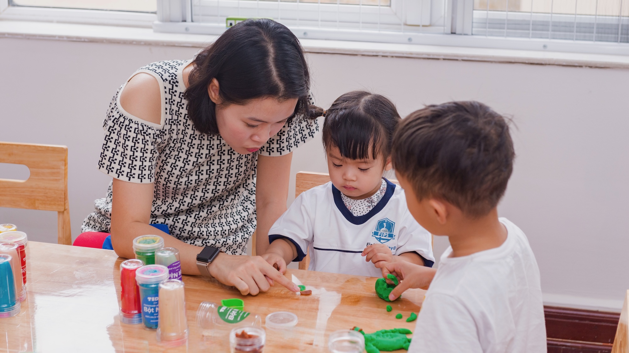 A key worker and child sharing a quiet, unhurried moment together — reading, talking, or simply sitting side by side. Intimacy and consistency visible in the ease and comfort between them.